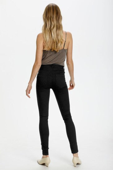 Black skinny jeggings with ripped knees, worn by a young woman with long, wavy blonde hair.