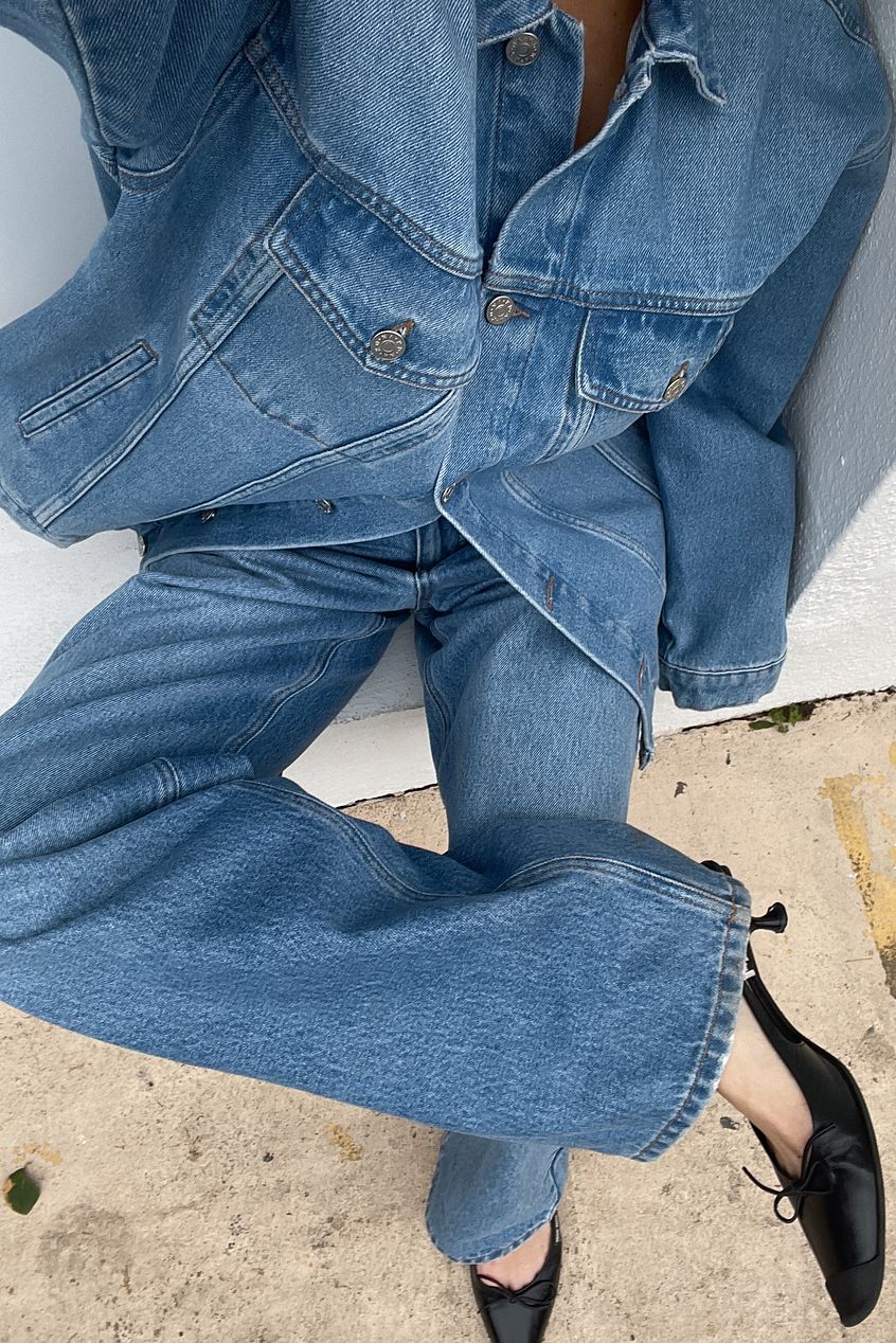 Pair of straight high-waist denim jeans with a classic blue wash, showcasing the Ace Cart brand and featuring pockets on the front and back.