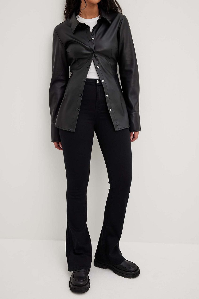 Flared High Waist Stretch Jeans - Black denim jeans featured in an image with a woman wearing a black jacket.