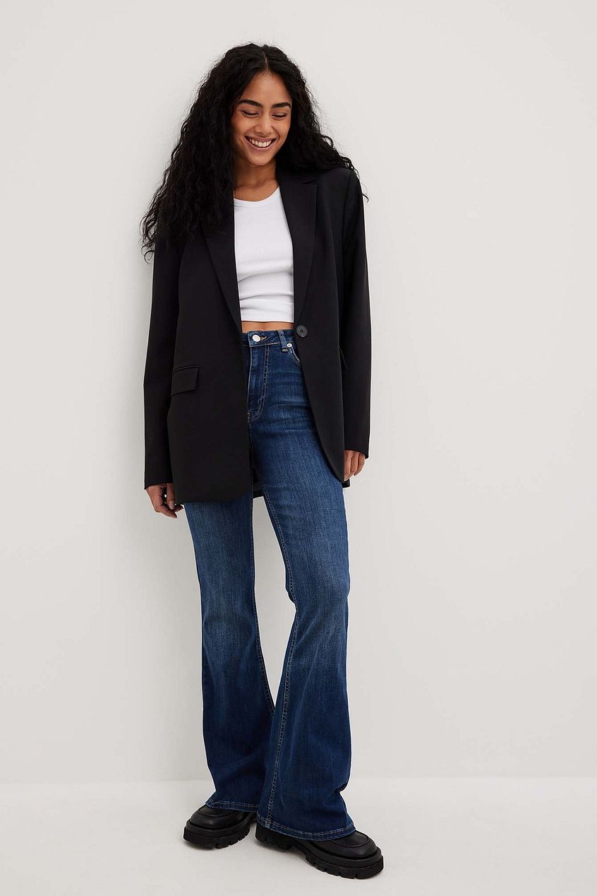 Flared High Waist Stretch Jeans from Ace Cart, fashionably styled with a black jacket and platform shoes.