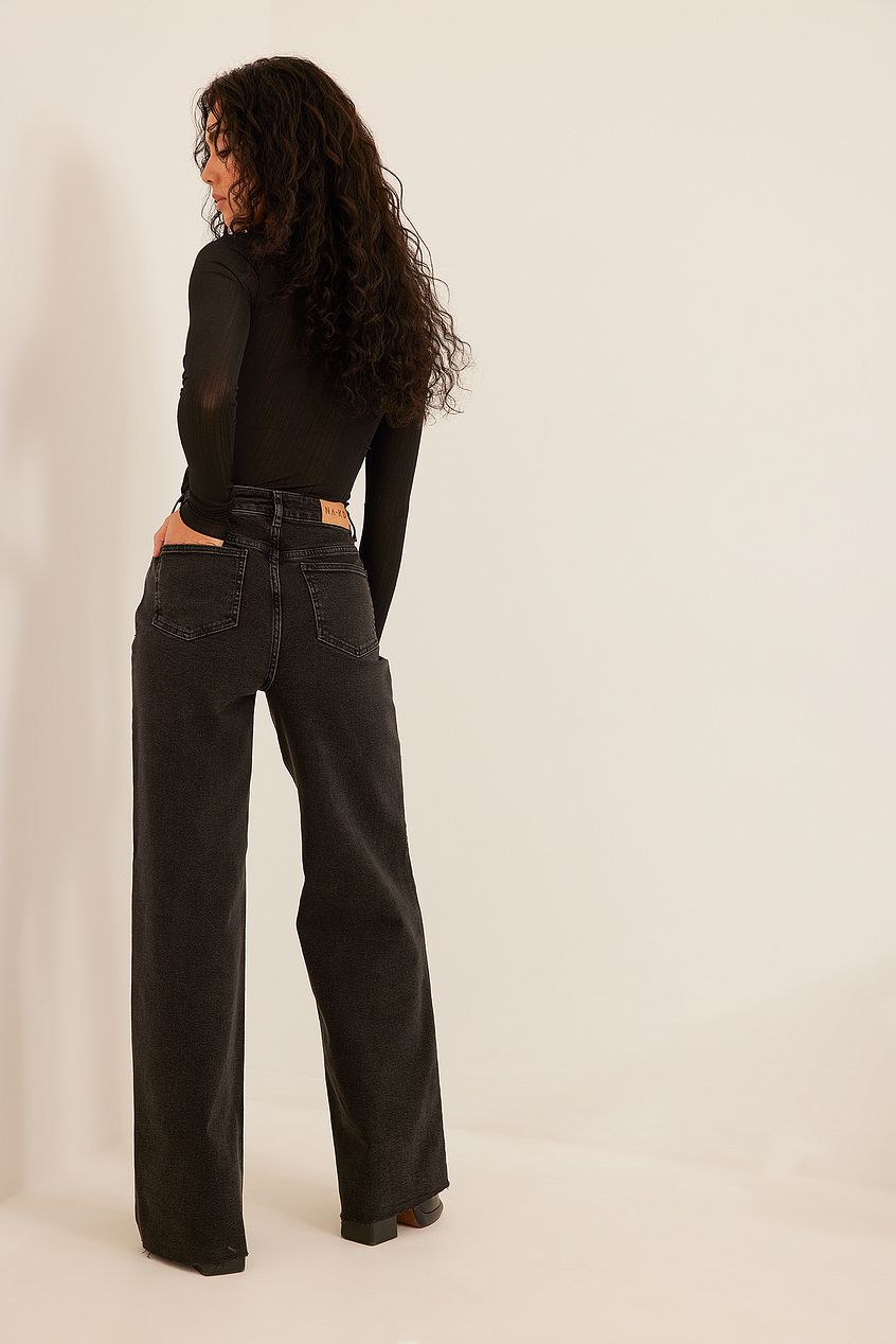 Raw Hem Denim - Black high-waist straight leg jeans with striking raw hem detail and curly long hair model