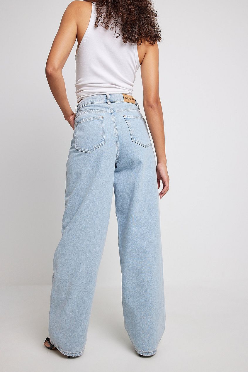 Wide-leg organic denim jeans with high-waist design, worn by a person with curly brown hair.
