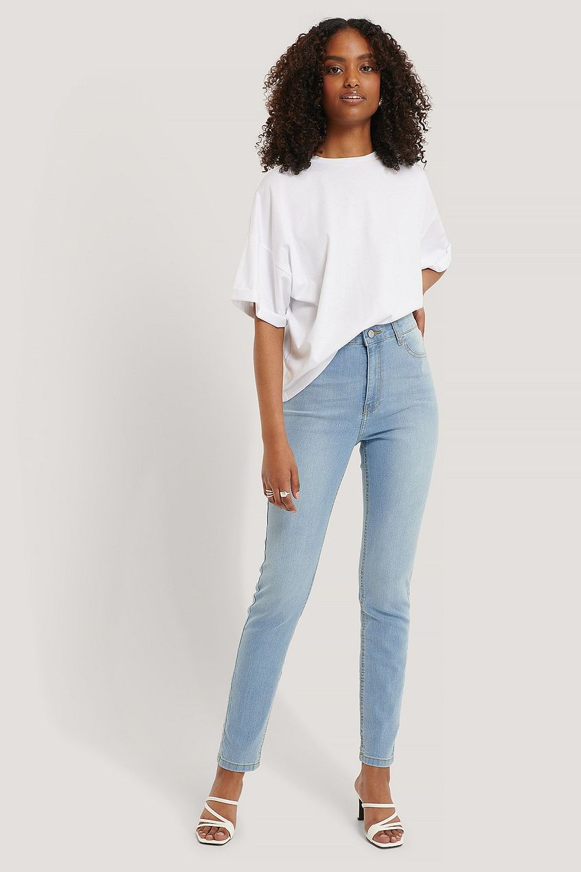 High-waist relaxed fit denim jeans with curled woman model wearing white casual top