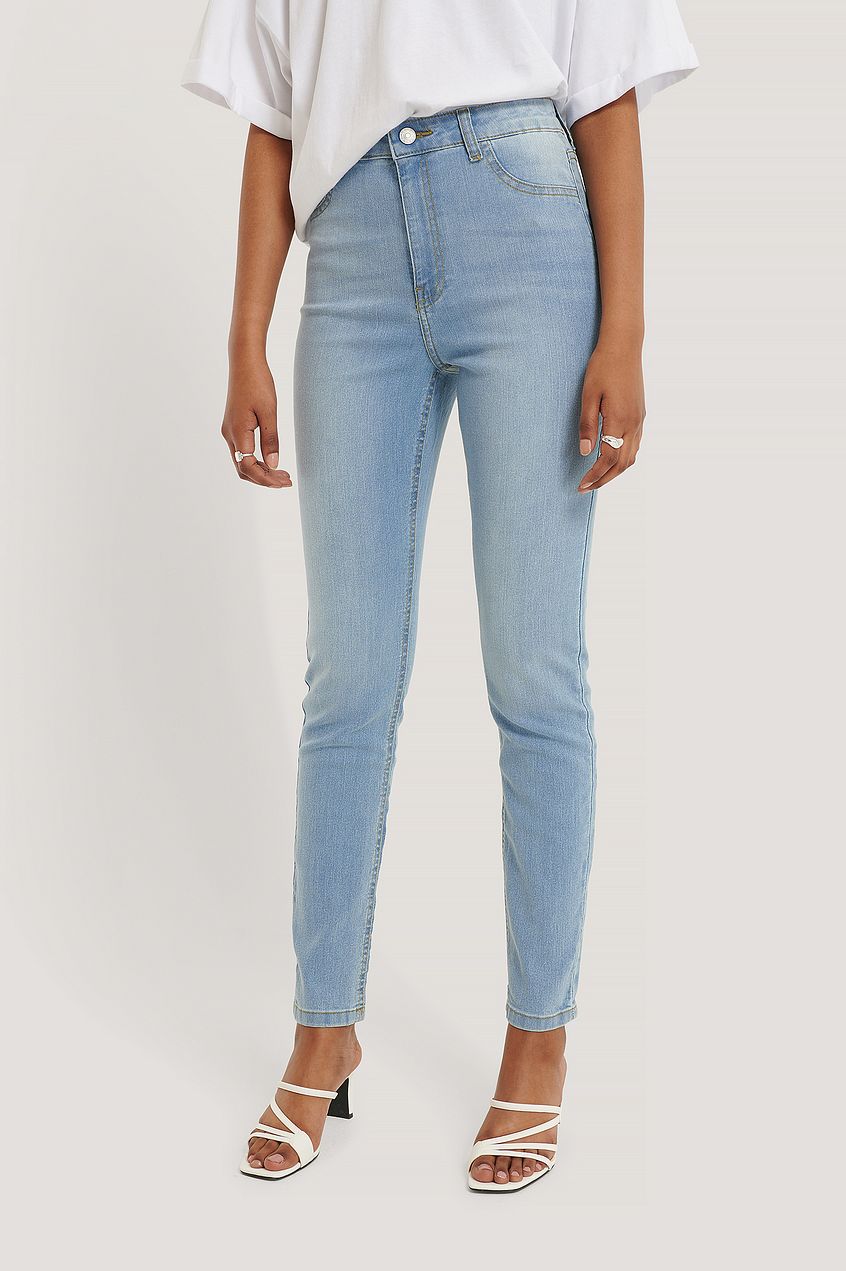 High-waist skinny jeans with a light blue denim color, worn by a young woman in the provided image.