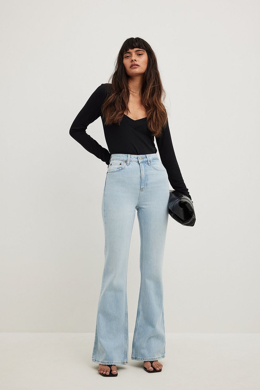 Flared High Waist Light Wash Denim Jeans from Ace Cart, worn by a young woman with long brown hair against a white background.