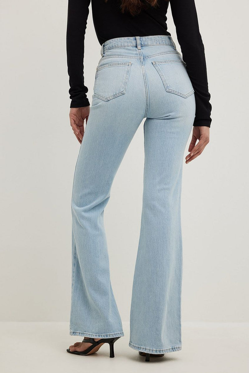 Flared high-waist light blue denim jeans showcased on a female model's lower body against a white background.