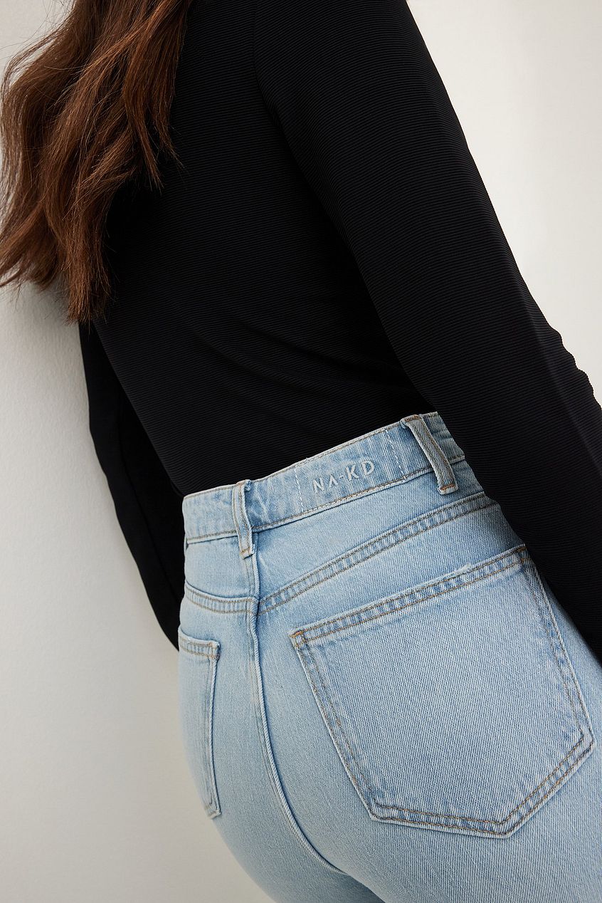 High-waist flared jeans in a light wash, featuring classic denim pockets and a fitted silhouette, displayed against a plain white background.