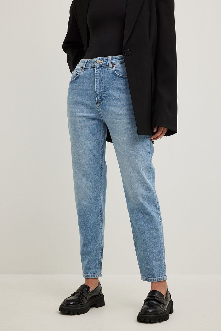 High-waist denim jeans with a straight leg silhouette, worn with a black sweater and chunky black shoes, capturing a stylish and casual fashion look.