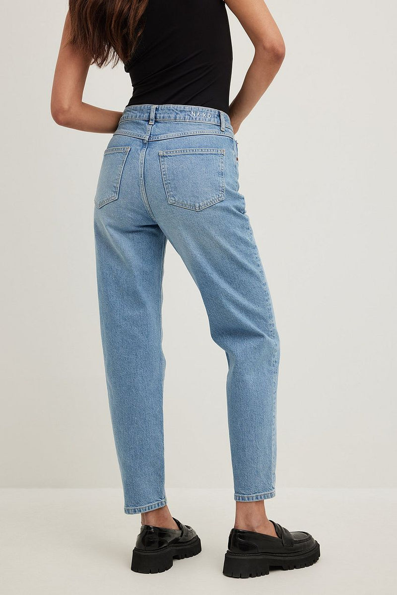 High-waist light-blue denim jeans with straight legs on a female model in a studio setting