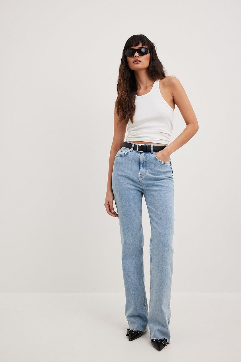 Flared High Waist Denim Jeans from Ace Cart - Stylish woman in white top and sunglasses poses in relaxed, flared leg jeans.