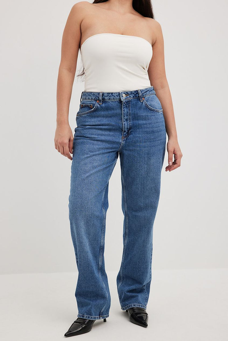 High-waist straight leg denim jeans in classic blue worn with a white strapless top featured in the image.