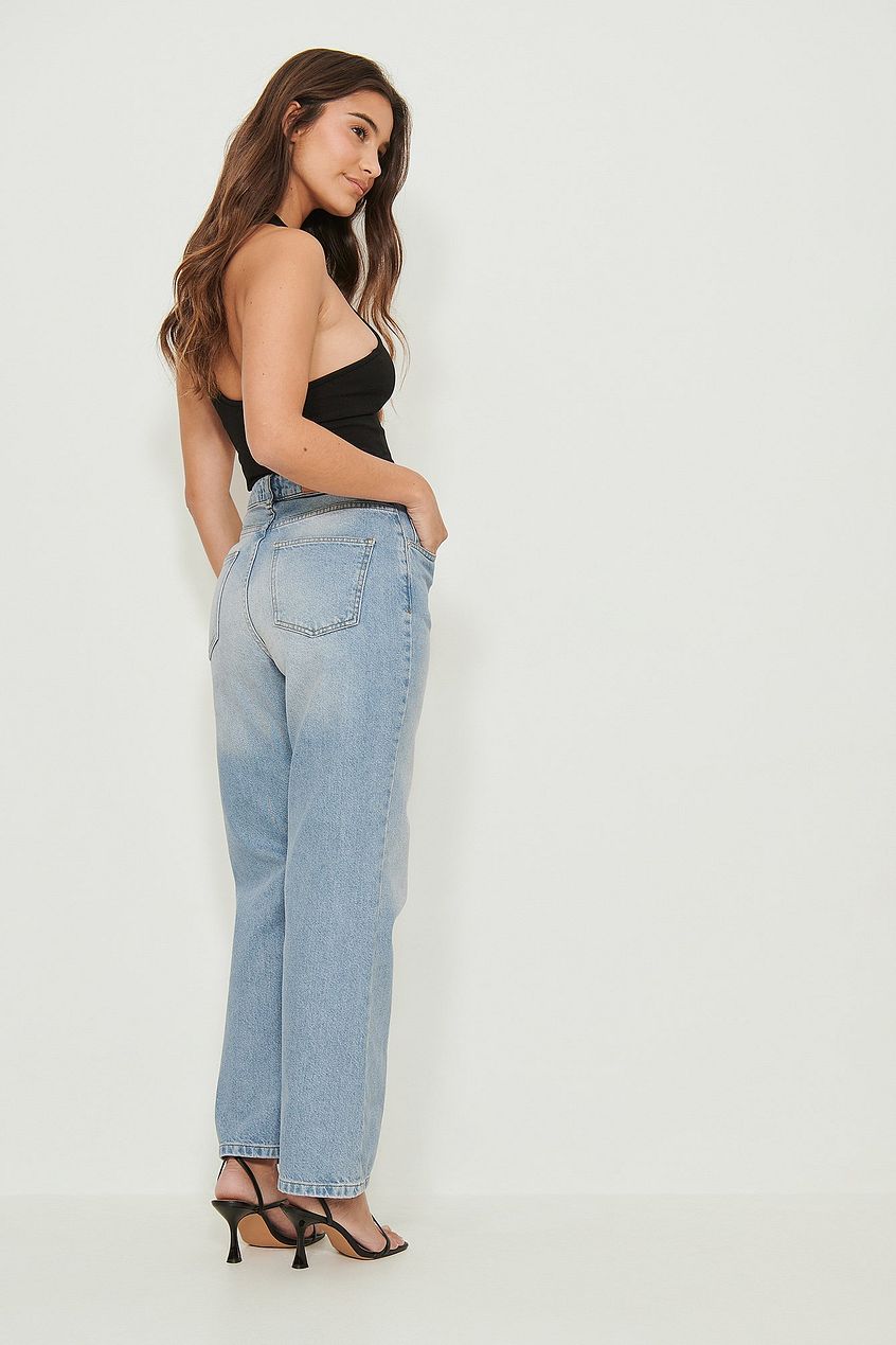 Relaxed fit high-waisted denim jeans, stylish model posing against a plain white background