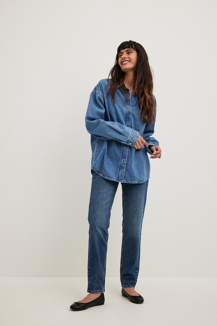 Stylish woman wearing slim mid waist jeans and a denim button-up shirt, showcasing a casual and comfortable denim-based outfit.