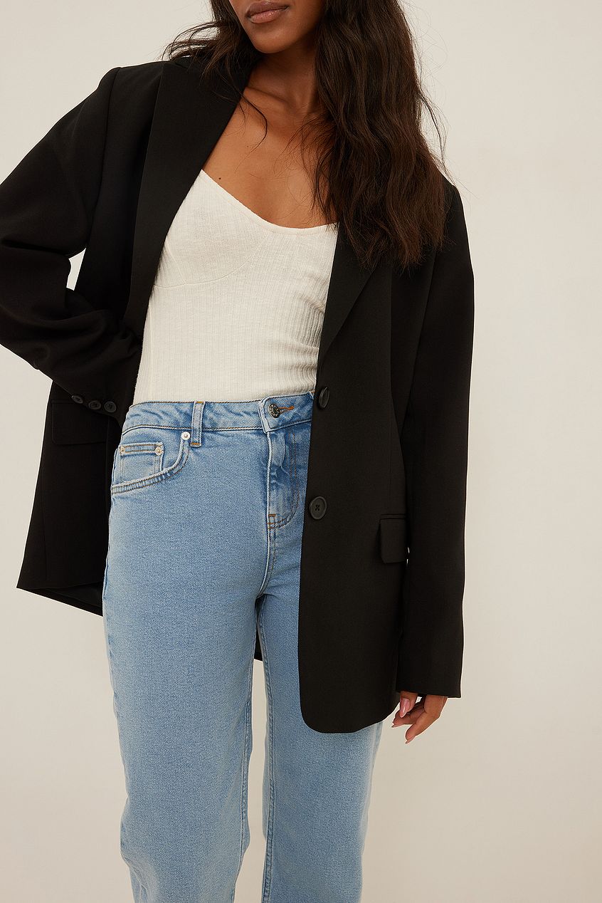 Mid Waist Slim Leg Denim Jeans by Ace Cart - Stylish and flattering denim jeans with a slim leg silhouette, complemented by a black blazer for a chic, modern look.