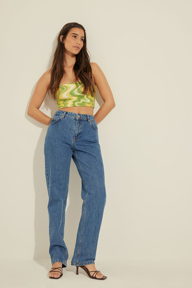 Striking mid rise straight leg jeans by Ace Cart, featured with a vibrant green patterned crop top in a minimalist studio setting.