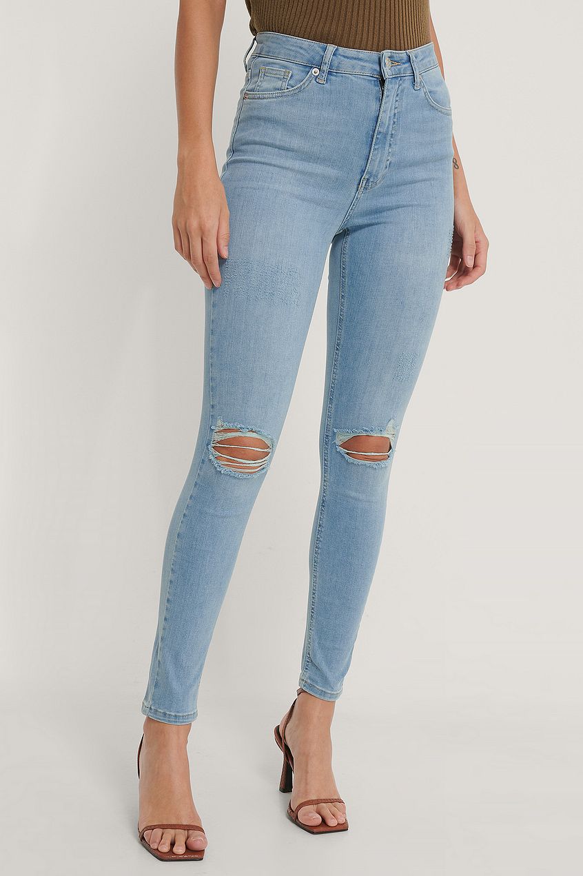 High-waist distressed organic skinny jeans showcased on a female model.