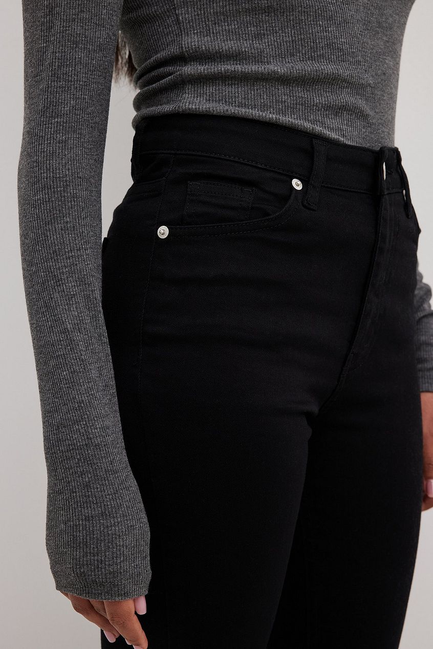 Skinny high-waist black denim jeans with an open hem design, featured in the product image.
