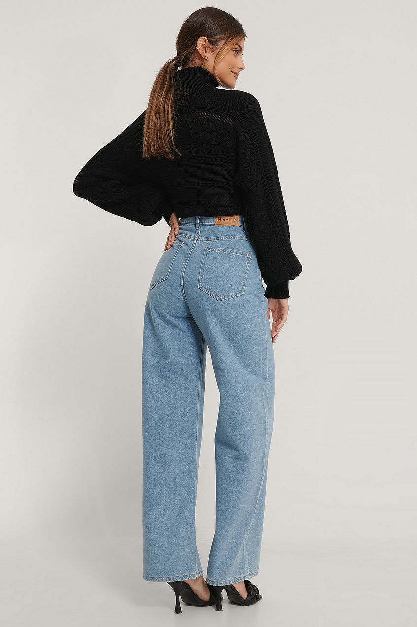 High-waist organic extra-wide leg denim jeans with a relaxed fit, paired with a cozy black textured sweater, showcasing a fashionable and comfortable casual outfit.