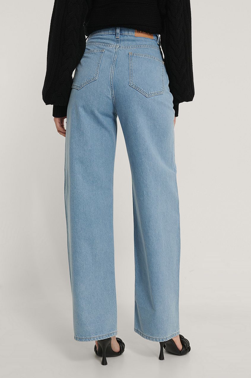 High-waisted wide leg denim jeans with functional pockets, worn by a model against a light background.