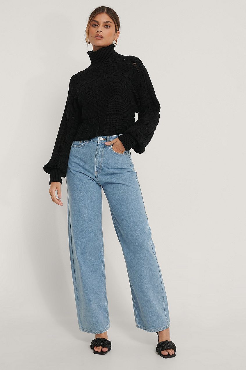 High waist denim with wide leg, black turtle neck sweater, female model posing in casual outfit