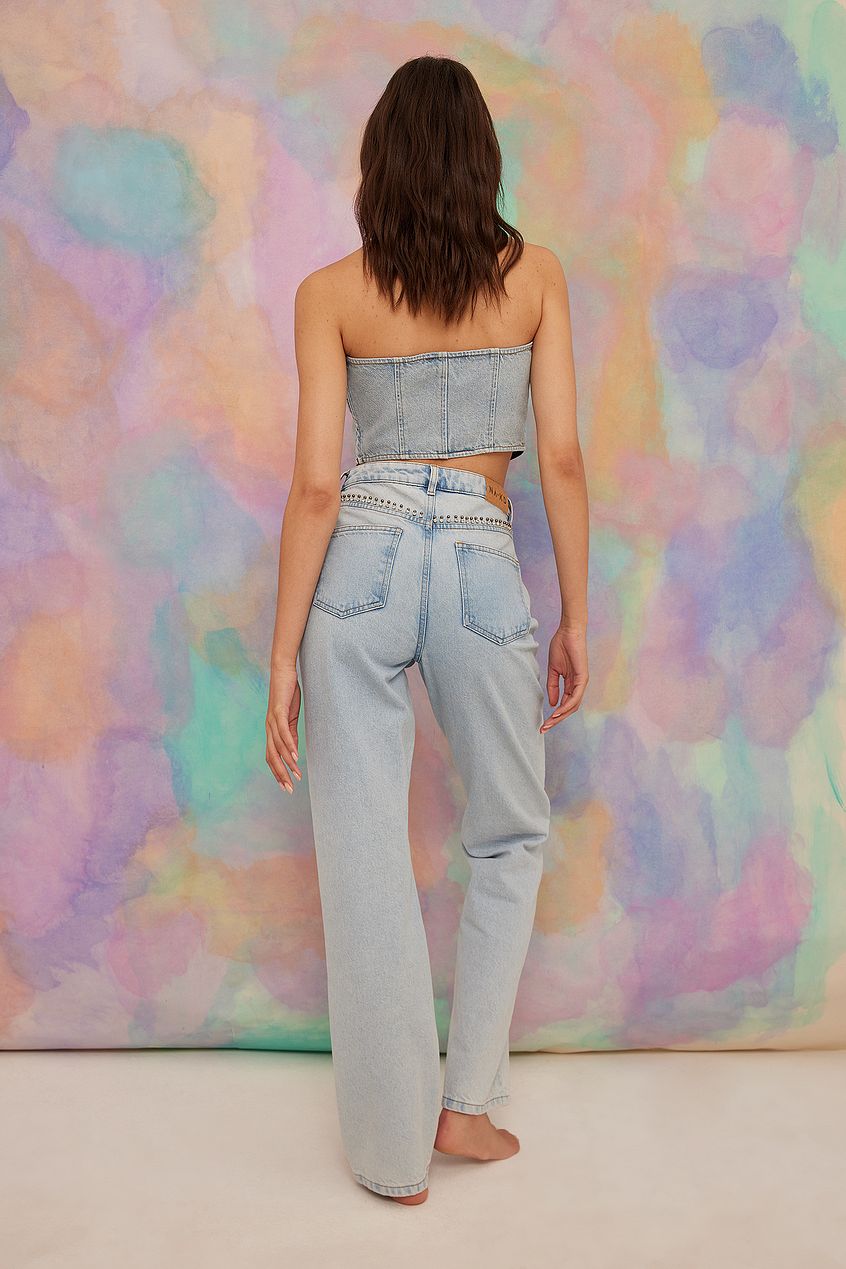Rhinestone Detail Denim: High-waist, straight-leg jeans with sparkling embellishments, displayed against a colorful abstract background.