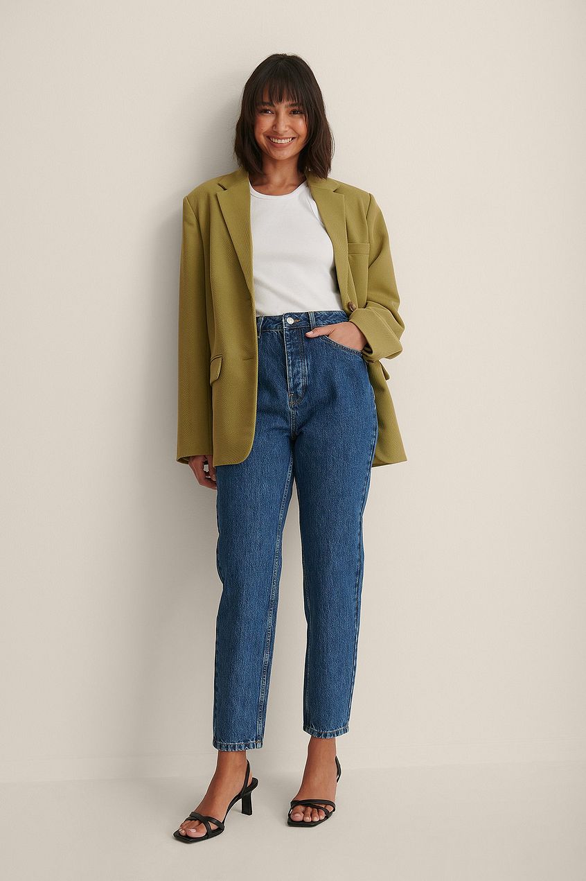 Relaxed denim style: High-waisted blue jeans, fitted white top, green blazer jacket. Stylish casual outfit for the modern woman.