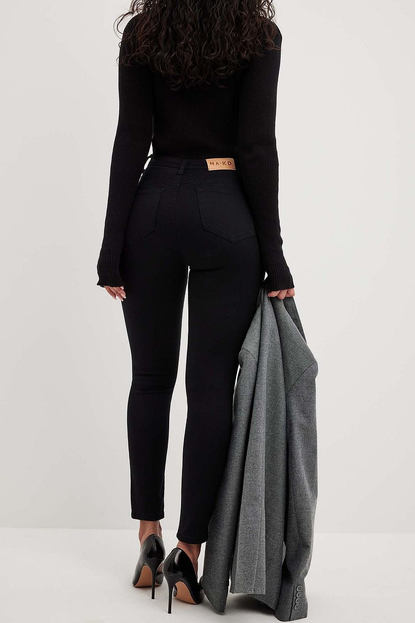 Skinny high-waist black stretch jeans with classic straight leg silhouette on display against a plain white background.