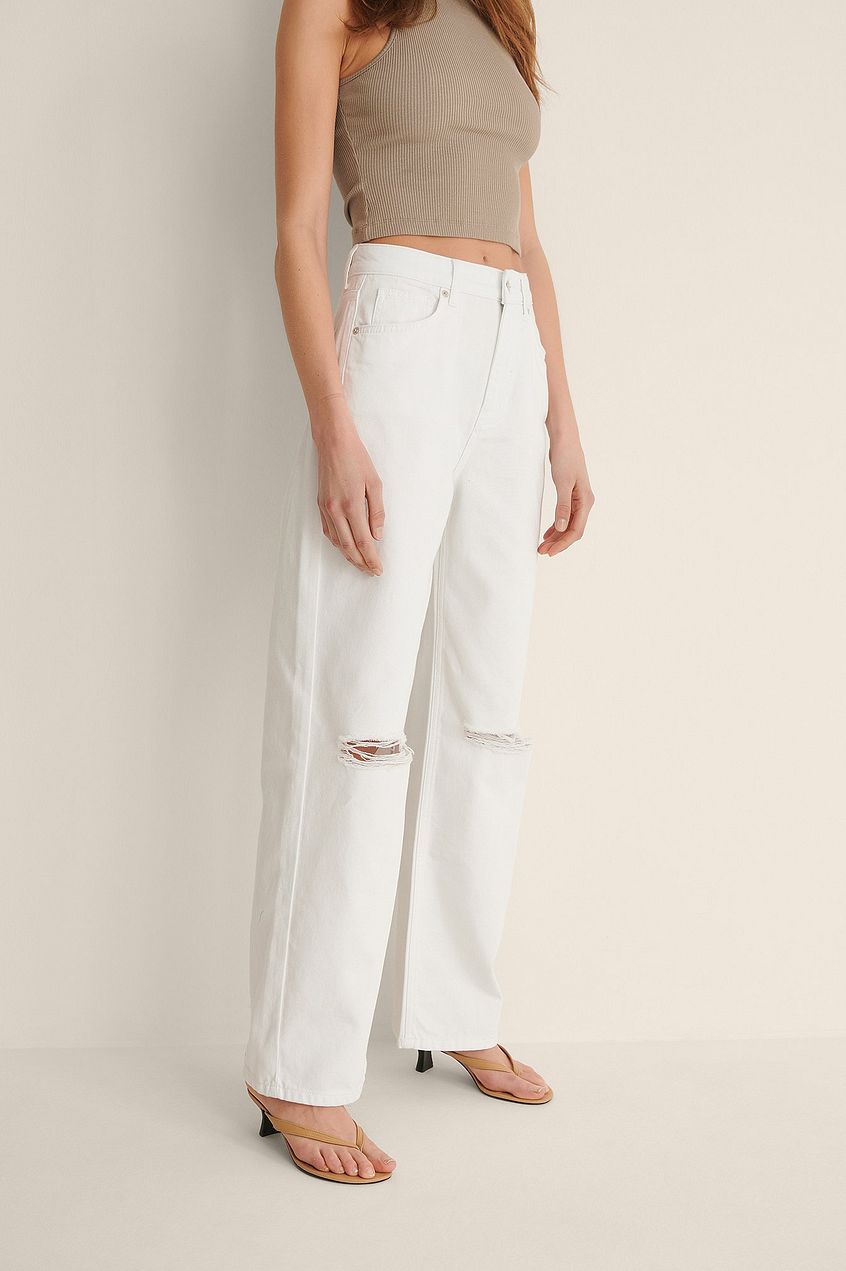 Organic Soft Rigid Wide Leg Destroyed White Jeans - Fashionable denim trousers with a relaxed fit and distressed details, showcased on a female model.