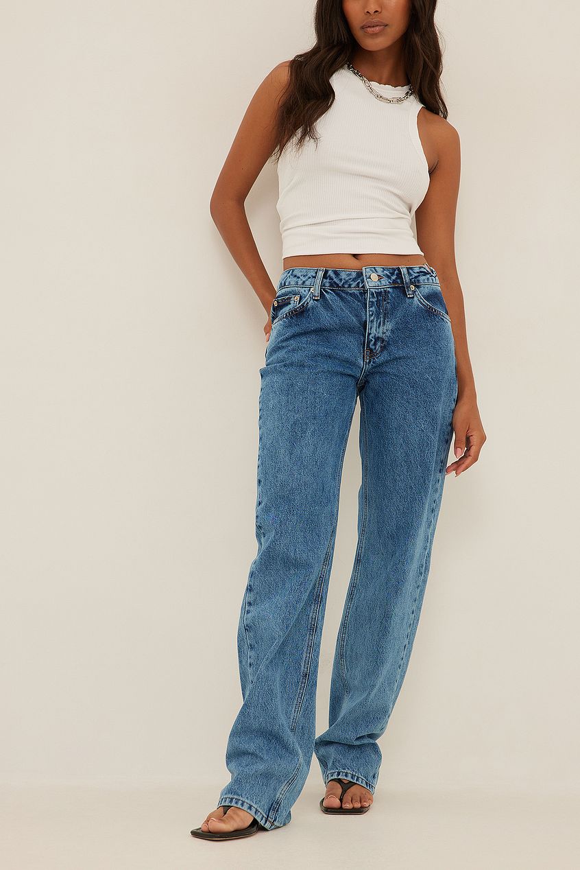 Waist Ring Detail Denim Jeans: Classic blue denim jeans with waist ring detail, worn by a woman with long brown hair.