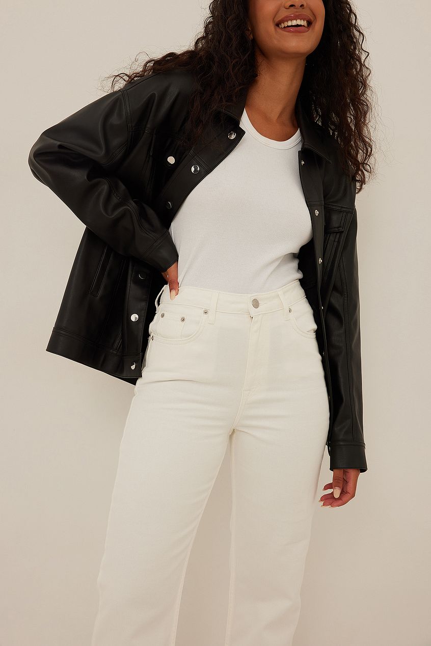 Wide leg cropped denim jeans with a black denim jacket on a smiling woman