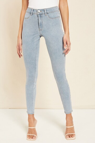 High-waisted denim jeggings with ripped knees, designed for a trendy, casual look.