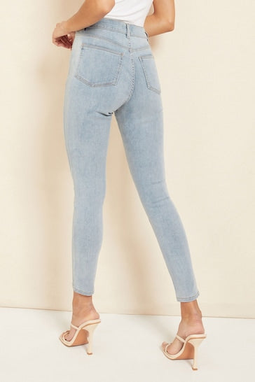 Sleek high-waisted jeggings with ripped knees, showcasing a stylish and comfortable denim look.