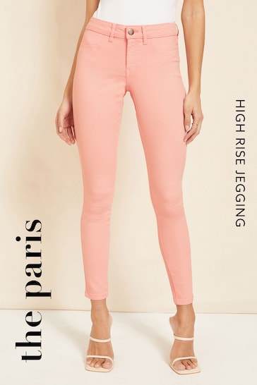 High-waisted stretch jeggings in a trendy pink color, shown on a female model against a plain background.
