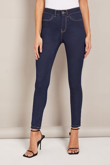 Dark high-waisted jeggings with ripped knees from Ace Cart, a stretchy and comfortable women's legging choice.