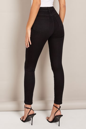 High-waisted black jeggings with a slim, stretchy fit showcased on a model's lower body.