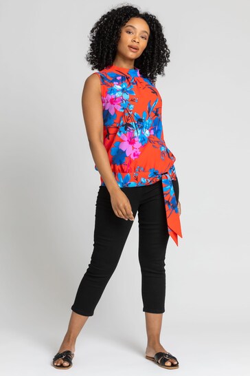 Bright and colorful floral print blouse, stylish black cropped pants, comfortable slip-on sandals, confident and poised young woman, eye-catching fashion ensemble.