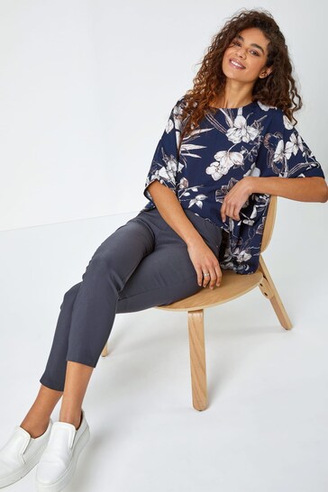 Navy blue floral print top with smiling woman in chair