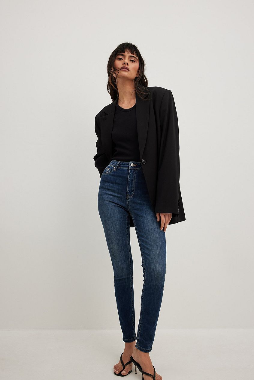 High waist stretch skinny jeans, black blazer, and heels on a female model against a white background.