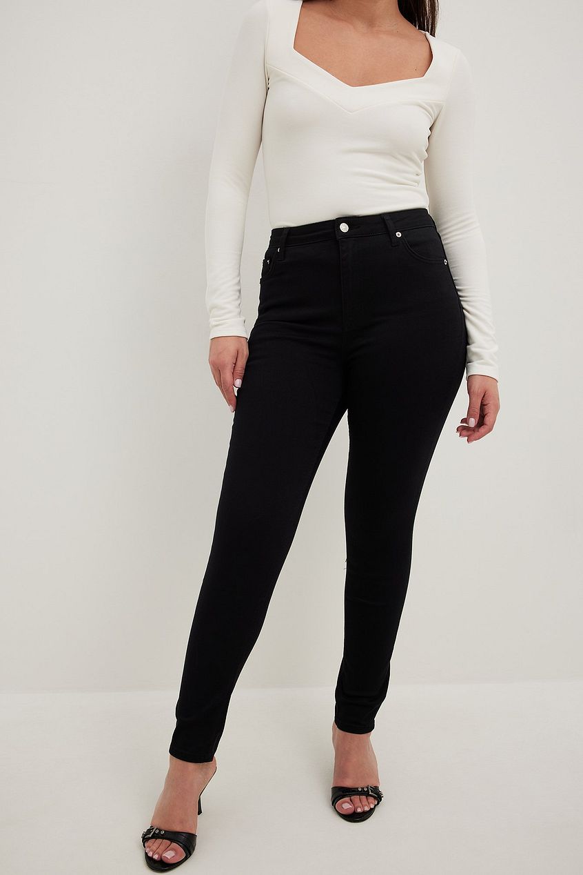 Skinny high-waist black denim jeans, worn by a female model on a white background.