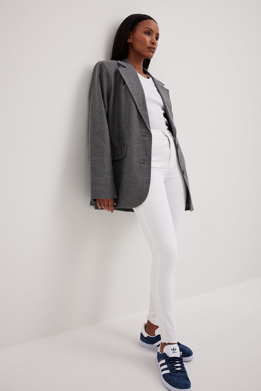 Stylish grey blazer, sleek white pants, and sporty navy sneakers - a modern and versatile fashion look.