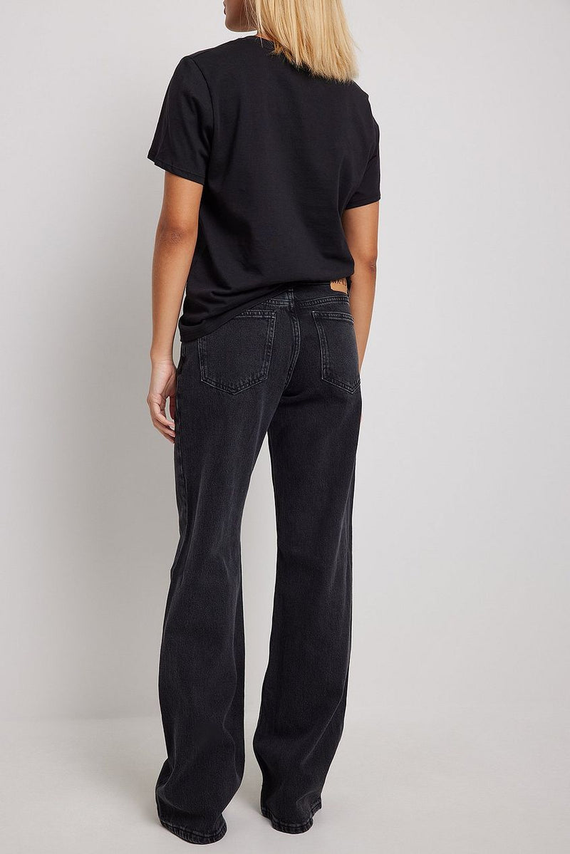 High-waisted wide leg black denim jeans with relaxed fit for women, featuring an oversized black t-shirt.