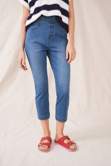 Blue denim cropped jeggings with a casual striped top and red sandals on model