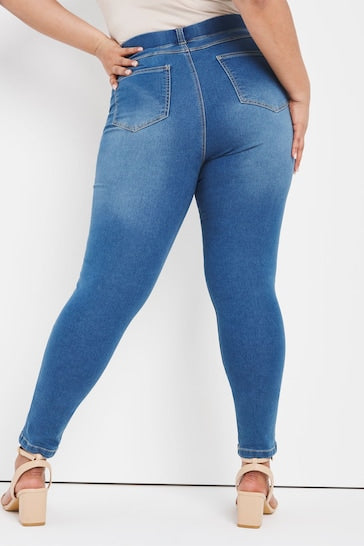 Mid blue skinny jeggings with ripped knees, showcased on a female model's lower body in the image.