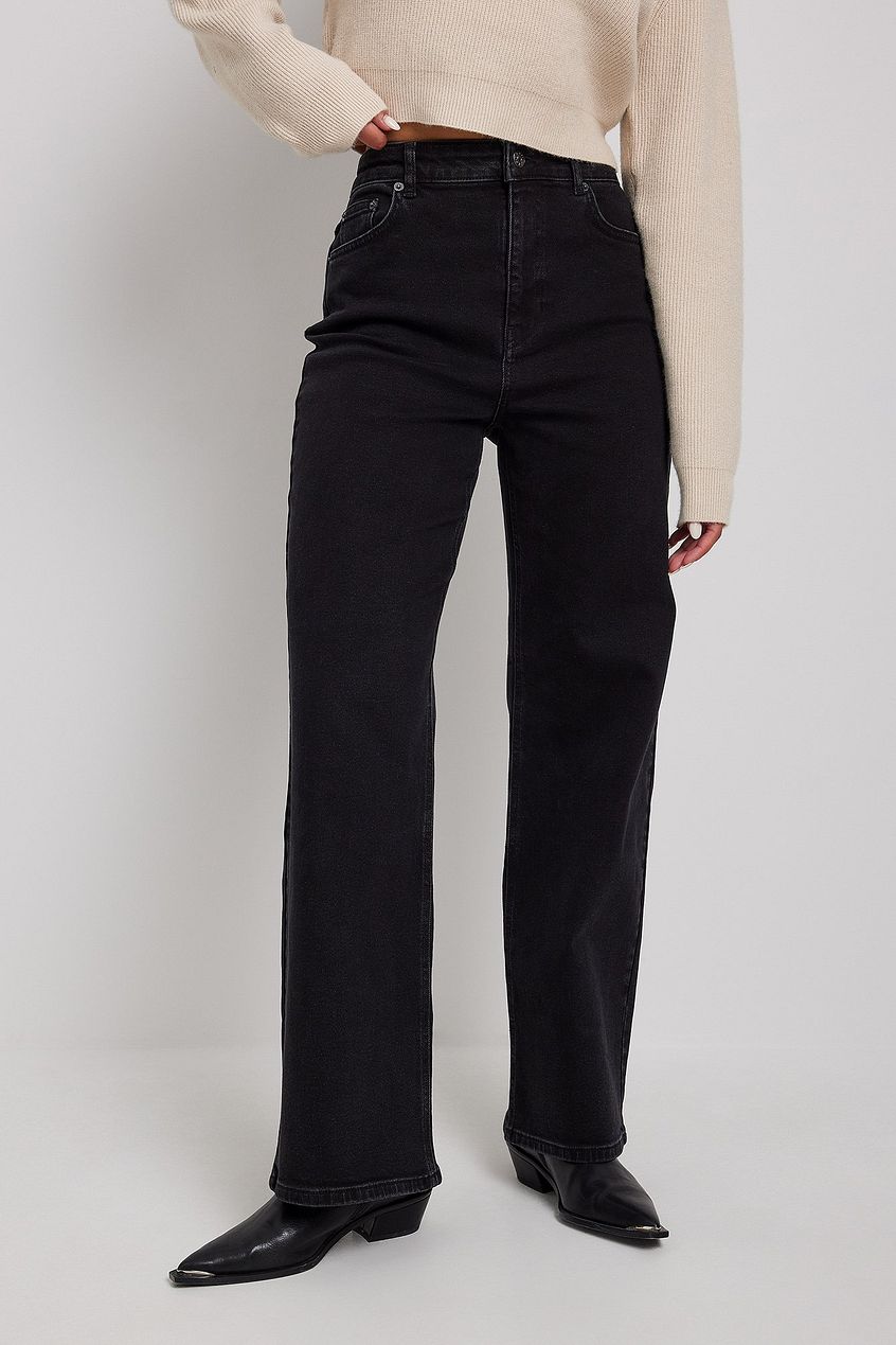 High-waist black denim jeans with a wide, relaxed fit displayed on a model wearing a neutral-toned top.